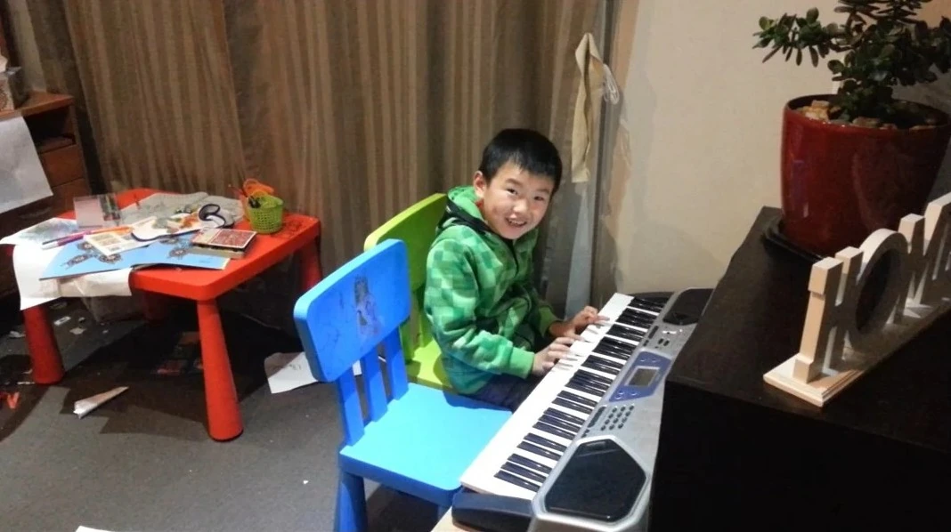 Young Isaac discovering music on a small Casio keyboard