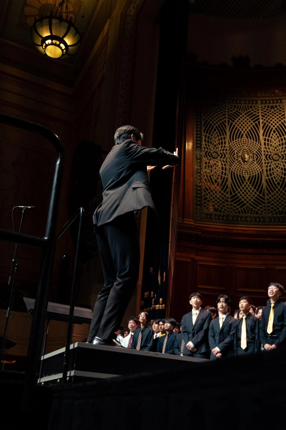 Isaac conducting the Melbourne High School choir from a raised platform