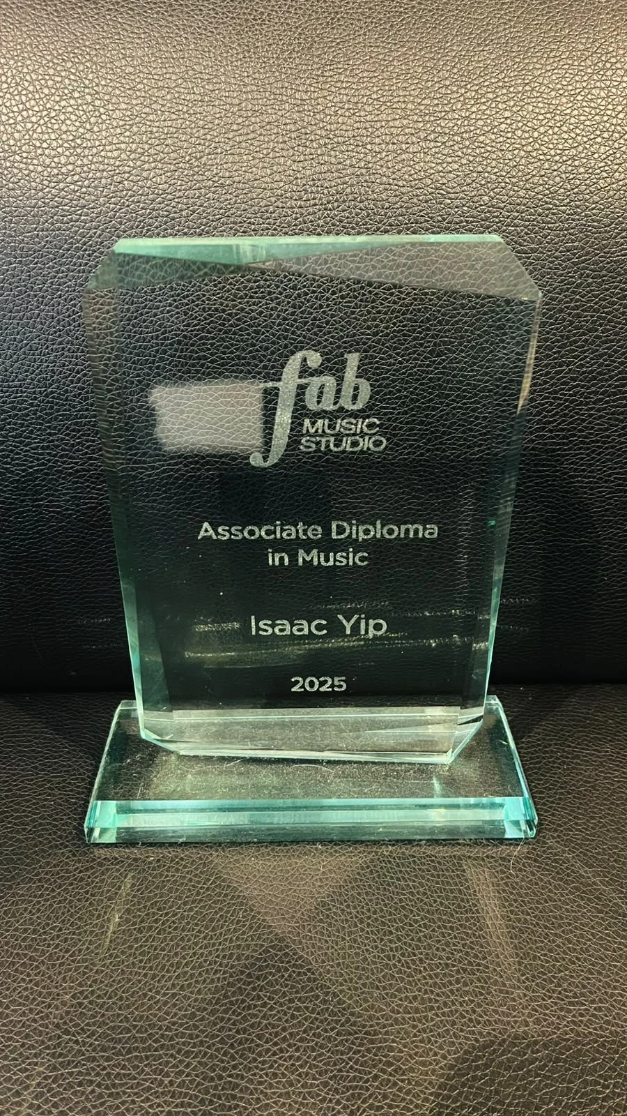 Glass recognition trophy presented to Isaac Yip by Fab Music Studio in 2025